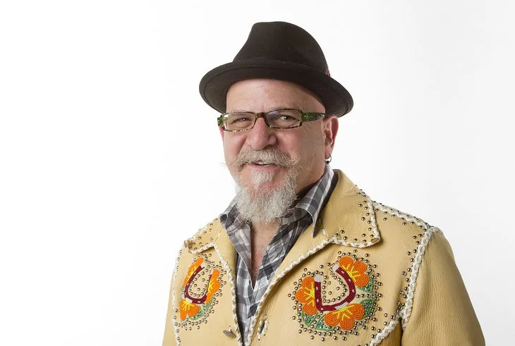 James Stone wearing a black hat and embroidered jacket